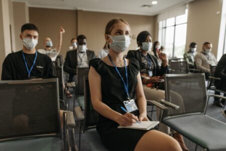 a group of journalists taking notes in a conference room